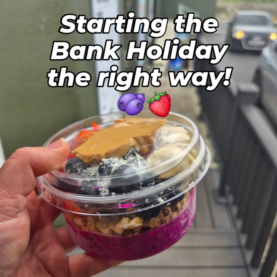 Close-up of a vibrant purple smoothie bowl topped with peanut butter and fruit